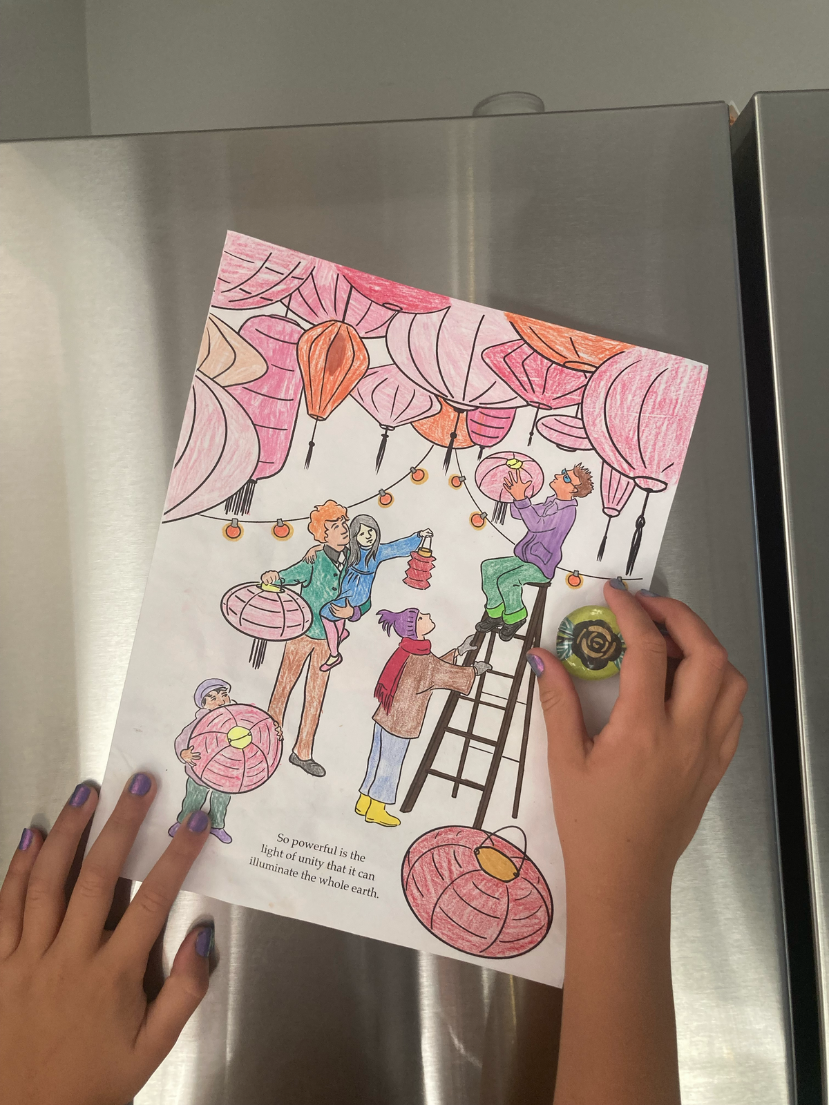 A child pinning their completed coloring page from the Beautiful Words coloring book onto a kitchen refrigerator, showcasing a lifestyle view of the book in use.